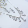 Silver jewelry set with necklace and earrings on a light background