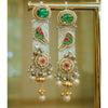 Ornate gold earrings with green and red gemstones on a blurred background