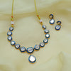 Jewelry set with necklace, earrings, and rakhi on a light yellow fabric background