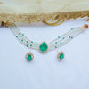 Jewelry set with necklace and earrings featuring green teardrop pendants on a white background.